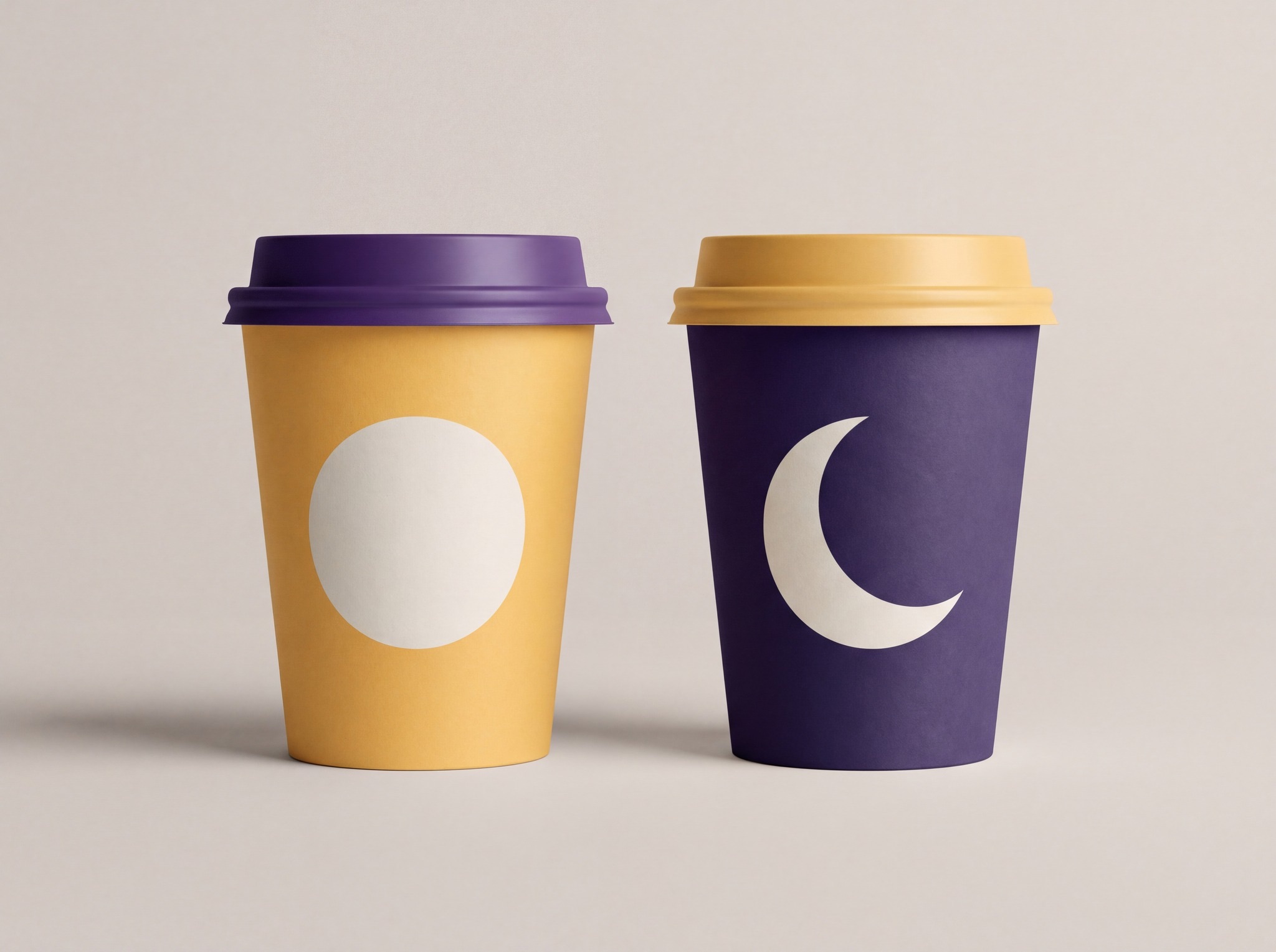 Two Wonder Bean takeaway cups: amber with a cream full moon and a purple lid, purple with a cream crescent and an amber lid