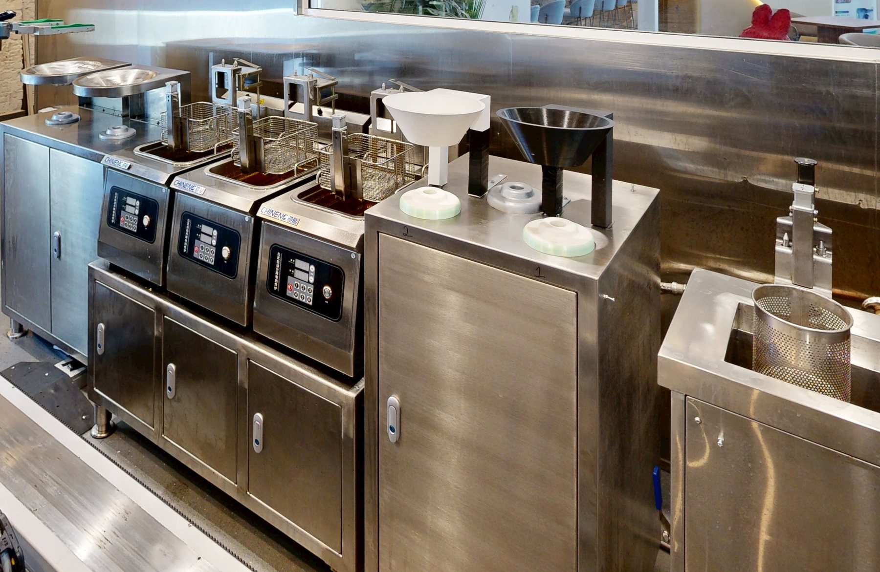 The fryers and dispensing funnels on the stainless line